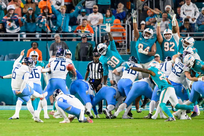 Miami Dolphins linebacker Jason Pierre-Paul (90), tackle Christian Wilkins (94), defensive tackle Zach Sieler (92) and defensive tackle Raekwon Davis (98) jump up to try to block the ball as Tennessee Titans kicker Nick Folk (6) kicks an extra point during an NFL football game, Monday, Dec. 12, 2023, in Miami Gardens, Fla. (AP Photo/Doug Murray)