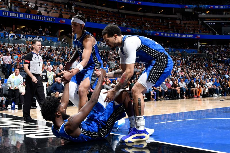 ORLANDO, FL - MARCH 23: Jonathan Isaac #1 of the Orlando Magic is helped up by Cole Anthony #50 and Paolo Banchero #5 during the game against the Sacramento Kings on March 23, 2024 at the Kia Center in Orlando, Florida. NOTE TO USER: User expressly acknowledges and agrees that, by downloading and or using this photograph, User is consenting to the terms and conditions of the Getty Images License Agreement. Mandatory Copyright Notice: Copyright 2024 NBAE (Photo by Fernando Medina/NBAE via Getty Images)