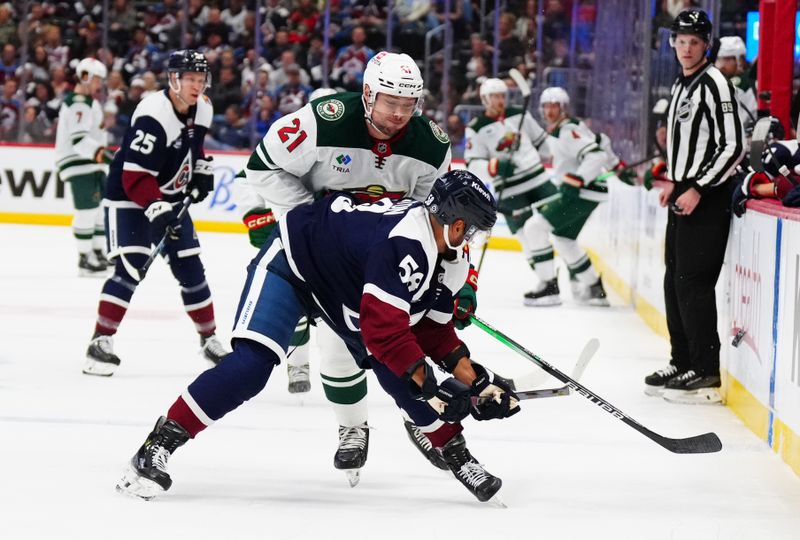 Feb 28, 2025; Denver, Colorado, USA; Minnesota Wild center Brendan Gaunce (21) defends on Colorado Avalanche defenseman Oliver Kylington (58) in the first period at Ball Arena. Mandatory Credit: Ron Chenoy-Imagn Images