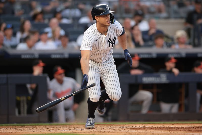 Jun 18, 2024; Bronx, New York, USA; New York Yankees designated hitter Giancarlo Stanton (27) hits an RBI single during the third inning against the Baltimore Orioles at Yankee Stadium. Mandatory Credit: Vincent Carchietta-USA TODAY Sports