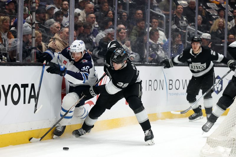 Apr 1, 2025; Los Angeles, California, USA;  Los Angeles Kings left wing Jeff Malott (39) fights for the puck against Winnipeg Jets center Morgan Barron (36) during the first period at Crypto.com Arena. Mandatory Credit: Kiyoshi Mio-Imagn Images