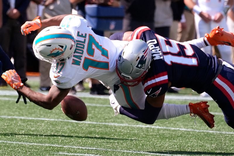 New England Patriots safety Marte Mapu (15) tackles Miami Dolphins wide receiver Jaylen Waddle (17), who drops a pass, during the first half of an NFL football game, Sunday, Oct. 6, 2024, in Foxborough, Mass. (AP Photo/Michael Dwyer)