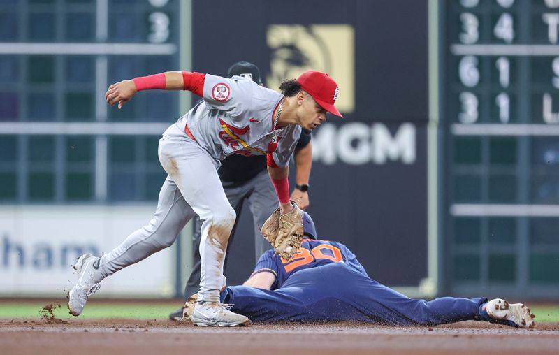 Jun 3, 2024; Houston, Texas, USA; Houston Astros right fielder Kyle Tucker (30) slides safely into second base with a stolen base as St. Louis Cardinals shortstop Masyn Winn (0) attempts to apply a tag during the first inning at Minute Maid Park. Mandatory Credit: Troy Taormina-USA TODAY Sports