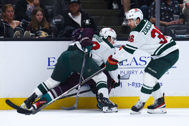 Mar 19, 2024; Anaheim, California, USA; Minnesota Wild center Marco Rossi (23) and right wing Ryan Hartman (38) fight for the puck against Anaheim Ducks right wing Brett Leason (20) during the second period of a game at Honda Center. Mandatory Credit: Jessica Alcheh-USA TODAY Sports