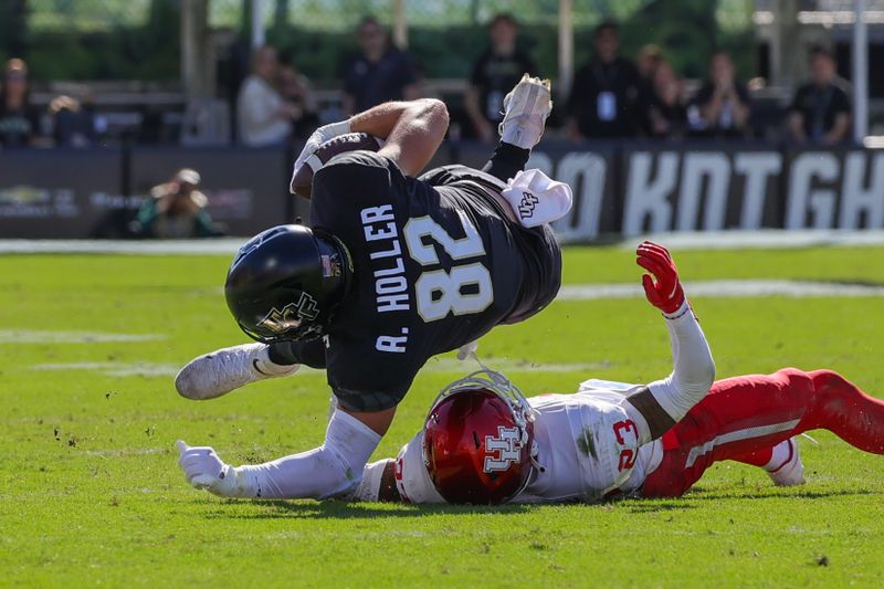 Nov 25, 2023; Orlando, Florida, USA; UCF Knights tight end Alec Holler (82) is tackled by Houston Cougars defensive back Isaiah Hamilton (23) during the second quarter at FBC Mortgage Stadium. Mandatory Credit: Mike Watters-USA TODAY Sports