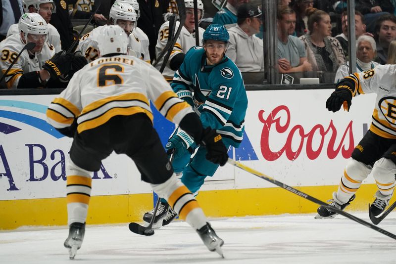 Nov 23, 2025; San Jose, California, USA;  San Jose Sharks center Alexander Wennberg (21) controls the puck in front of Boston Bruins defenseman Mason Lohrei (6) in the second period at SAP Center in San Jose. Mandatory Credit: David Gonzales-Imagn Images