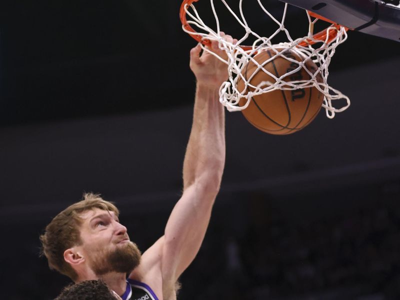 DENVER, COLORADO - FEBRUARY 28: Domantas Sabonis #10 of the Sacramento Kings dunks the ball while Michael Porter Jr. #1 of the Denver Nuggets defends during the game at Ball Arena on February 28, 2024 in Denver, Colorado. NOTE TO USER: User expressly acknowledges and agrees that, by downloading and or using this photograph, User is consenting to the terms and conditions of the Getty Images License Agreement. (Photo by Alysa Rubin/Clarkson Creative/Getty Images)