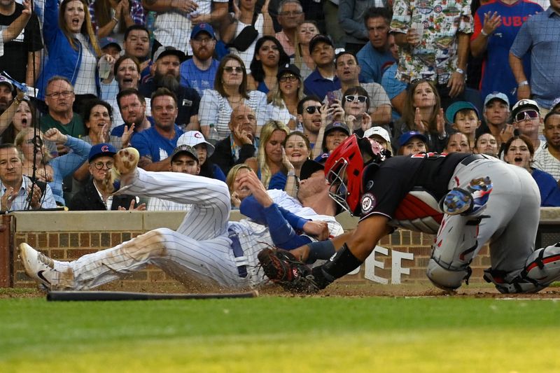 Jul 17, 2023; Chicago, Illinois, USA;  Chicago Cubs center fielder Cody Bellinger (24) scores past Washington Nationals catcher Keibert Ruiz (20) during the second inning at Wrigley Field. Mandatory Credit: Matt Marton-USA TODAY Sports