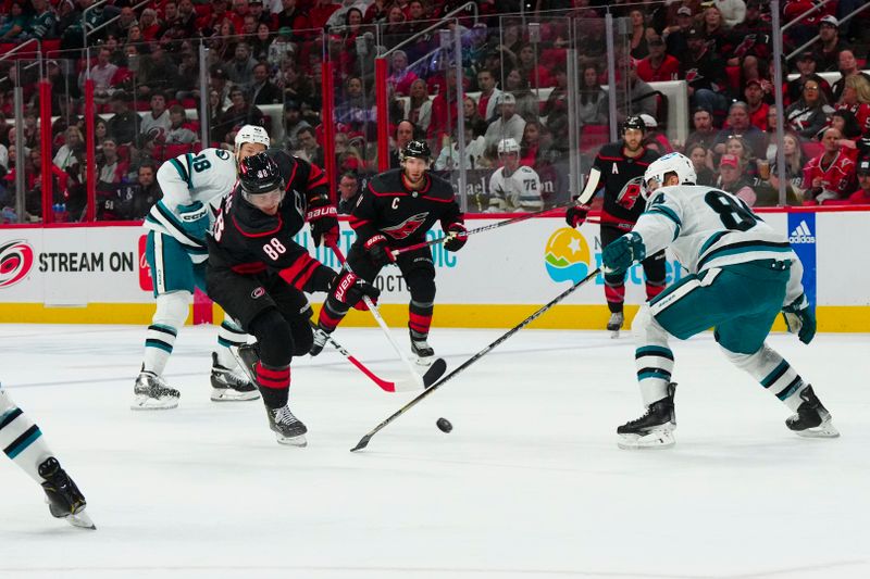 Oct 27, 2023; Raleigh, North Carolina, USA; Carolina Hurricanes center Martin Necas (88) takes a shot against San Jose Sharks defenseman Jan Rutta (84) during the first period at PNC Arena. Mandatory Credit: James Guillory-USA TODAY Sports