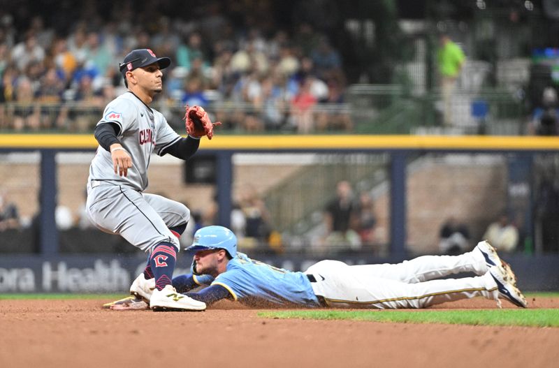 Aug 16, 2024; Milwaukee, Wisconsin, USA; Milwaukee Brewers second base Brice Turang (2) steals second base ahead of the tag by Cleveland Guardians second base Andres Gimenez (0) in the fourth inning at American Family Field. Mandatory Credit: Michael McLoone-USA TODAY Sports