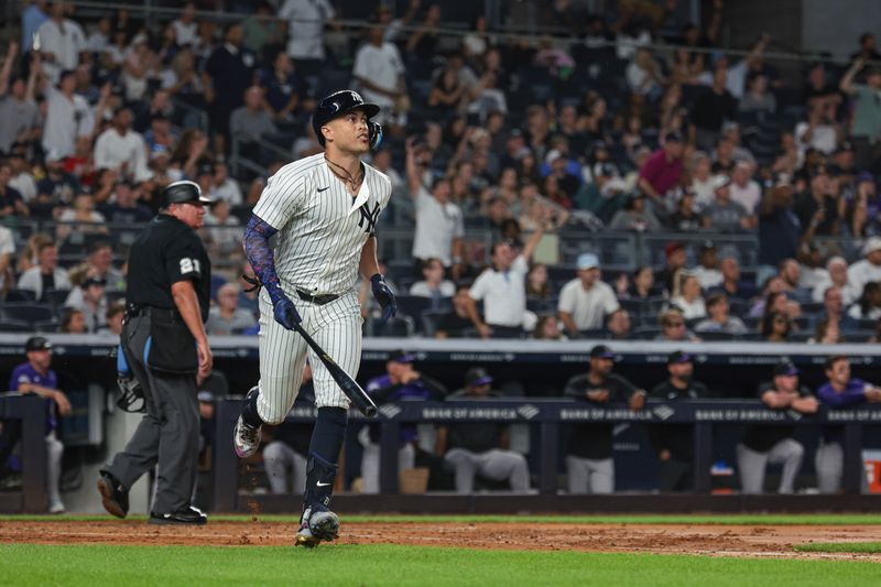Aug 23, 2024; Bronx, New York, USA;  New York Yankees designated hitter Giancarlo Stanton (27) hits a solo home run during the fourth inning against the Colorado Rockies at Yankee Stadium. Mandatory Credit: Vincent Carchietta-USA TODAY Sports