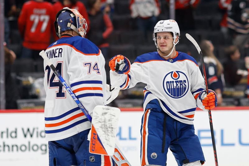 Nov 24, 2023; Washington, District of Columbia, USA; Edmonton Oilers center Mattias Janmark (13) hands the puck to Oilers goaltender Stuart Skinner (74) after their game against the Washington Capitals at Capital One Arena. Mandatory Credit: Geoff Burke-USA TODAY Sports