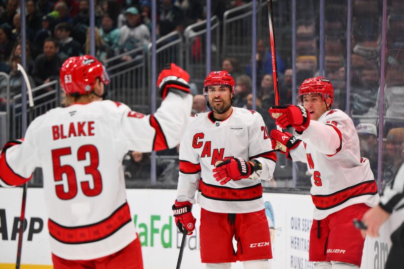 Oct 26, 2024; Seattle, Washington, USA; Carolina Hurricanes right wing Jackson Blake (53) and left wing William Carrier (28) and center Jack Drury (18) celebrate after a goal scored by Drury during the second period against the Seattle Kraken at Climate Pledge Arena. Mandatory Credit: Steven Bisig-Imagn Images