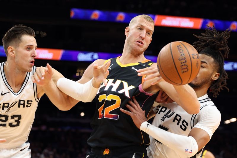 PHOENIX, ARIZONA - DECEMBER 03: Mason Plumlee #22 of the Phoenix Suns battles for a rebound with Zach Collins #23 of the San Antonio Spurs and Stephon Castle #5 during the first half of the Emirates NBA Cup game at Footprint Center on December 03, 2024 in Phoenix, Arizona. NOTE TO USER: User expressly acknowledges and agrees that, by downloading and or using this photograph, User is consenting to the terms and conditions of the Getty Images License Agreement.  (Photo by Chris Coduto/Getty Images)