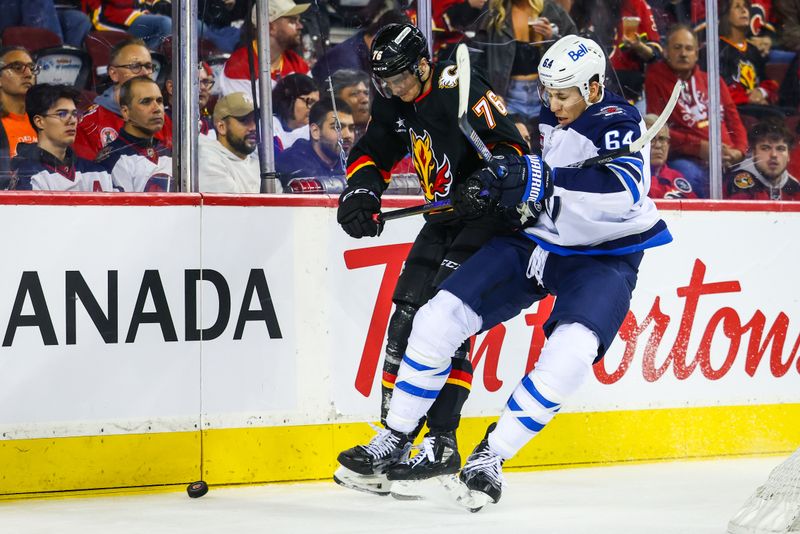 Oct 26, 2024; Calgary, Alberta, CAN; Calgary Flames center Martin Pospisil (76) and Winnipeg Jets defenseman Logan Stanley (64) battles for the puck during the second period at Scotiabank Saddledome. Mandatory Credit: Sergei Belski-Imagn Images