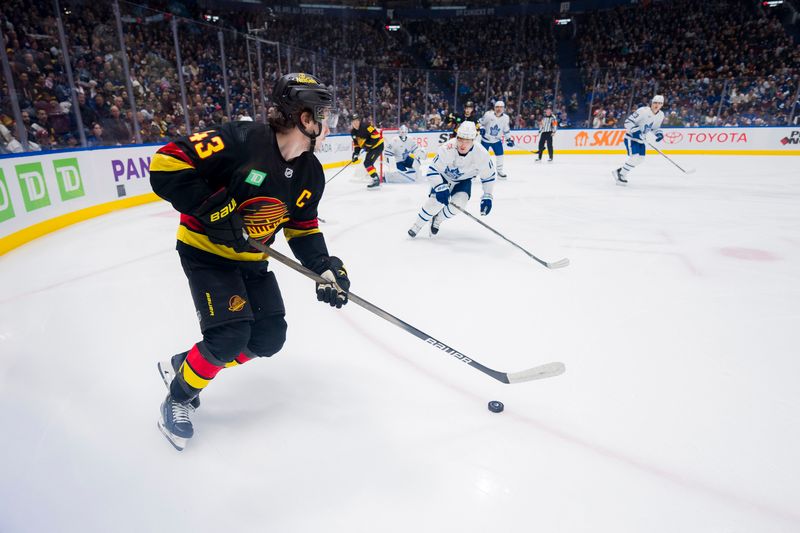 Jan 20, 2024; Vancouver, British Columbia, CAN; Vancouver Canucks defenseman Quinn Hughes (43) handles the puck against the Toronto Maple Leafs in the second period at Rogers Arena. Mandatory Credit: Bob Frid-USA TODAY Sports