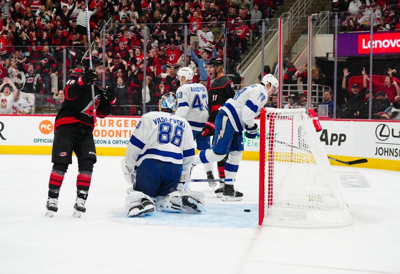 Oct 11, 2024; Raleigh, North Carolina, USA;  Carolina Hurricanes center Jordan Staal (11) scores a goal past Tampa Bay Lightning goaltender Andrei Vasilevskiy (88) and defenseman Emil Lilleberg (78) during the first period at PNC Arena. Mandatory Credit: James Guillory-Imagn Images