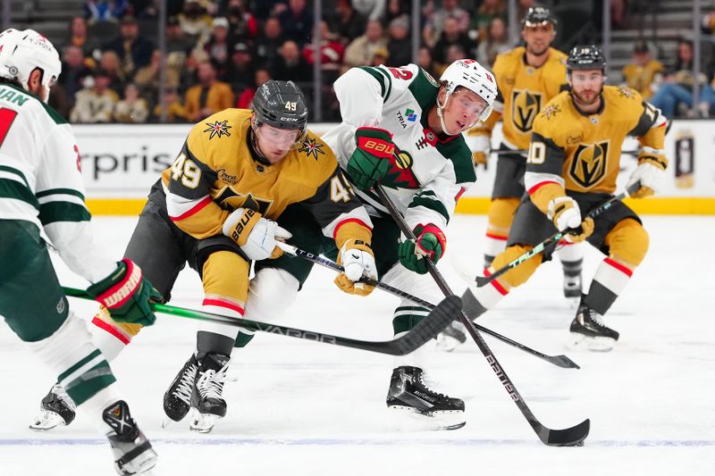 Feb 12, 2024; Las Vegas, Nevada, USA; Minnesota Wild left wing Matt Boldy (12) keeps the puck away from Vegas Golden Knights center Ivan Barbashev (49) during the first period at T-Mobile Arena. Mandatory Credit: Stephen R. Sylvanie-USA TODAY Sports