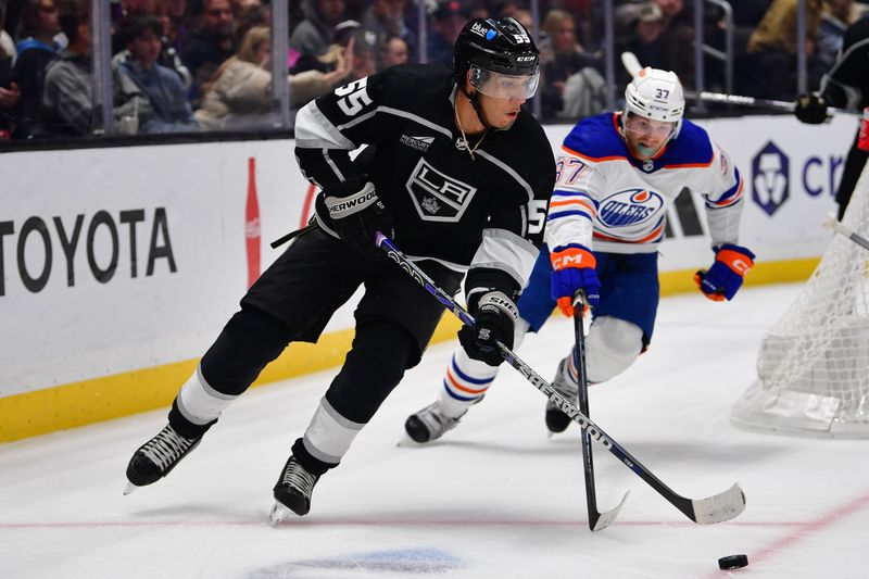 Dec 30, 2023; Los Angeles, California, USA; Los Angeles Kings right wing Quinton Byfield (55) moves the puck ahead of Edmonton Oilers left wing Warren Foegele (37) during the third period at Crypto.com Arena. Mandatory Credit: Gary A. Vasquez-USA TODAY Sports