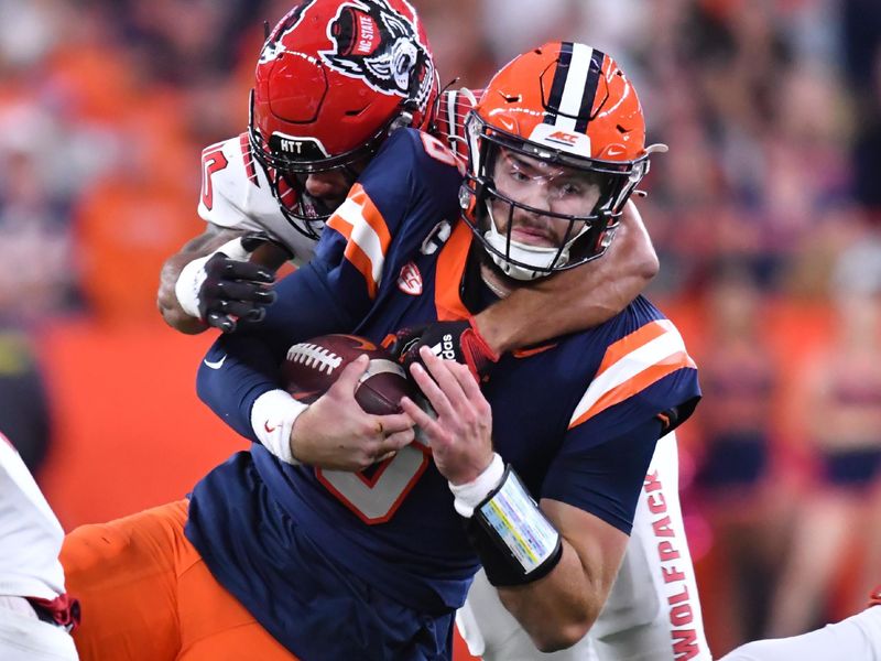 Oct 15, 2022; Syracuse, New York, USA; Syracuse Orange quarterback Garrett Shrader (6) is tackled by North Carolina State Wolfpack safety Tanner Ingle (10) in the third quarter at JMA Wireless Dome. Mandatory Credit: Mark Konezny-USA TODAY Sports