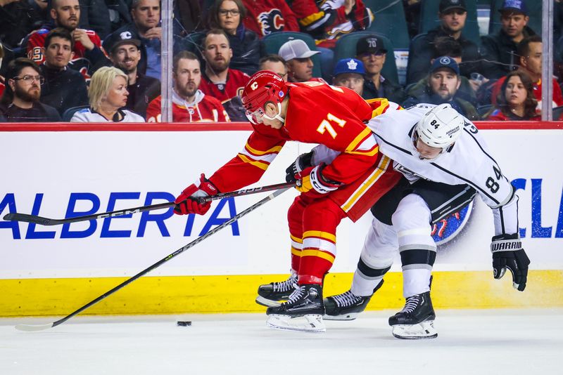 Mar 28, 2023; Calgary, Alberta, CAN; Calgary Flames right wing Walker Duehr (71) and Los Angeles Kings defenseman Vladislav Gavrikov (84) battle for the puck during the second period at Scotiabank Saddledome. Mandatory Credit: Sergei Belski-USA TODAY Sports