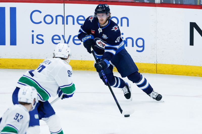 Mar 7, 2026; Winnipeg, Manitoba, CAN;  Winnipeg Jets forward Kyle Connor (81) skates in on Vancouver Canucks forward Liam Ohgren (92) during the third period at Canada Life Centre. Mandatory Credit: Terrence Lee-Imagn Images