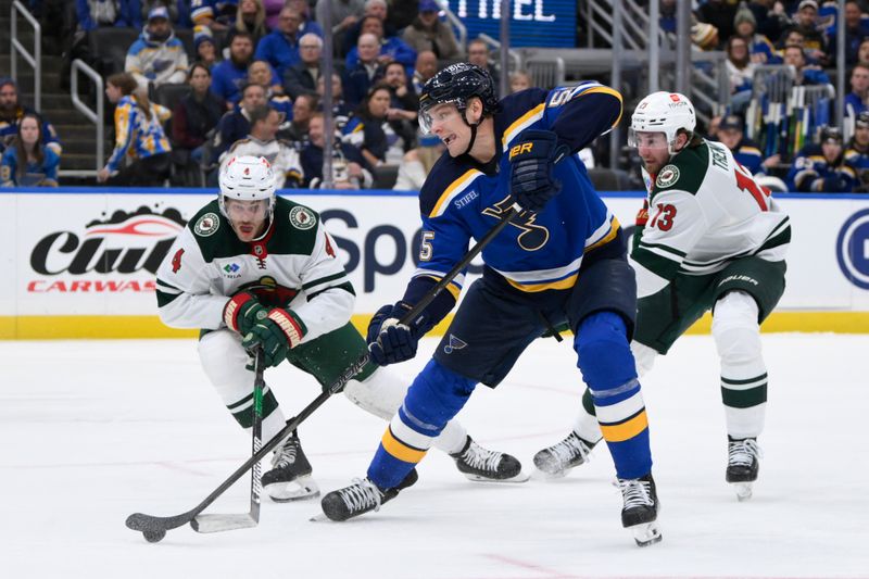 Oct 15, 2024; St. Louis, Missouri, USA; St. Louis Blues defenseman Colton Parayko (55) battles Minnesota Wild defenseman Jon Merrill (4) and center Yakov Trenin (13) during the second period at Enterprise Center. Mandatory Credit: Jeff Le-Imagn Images