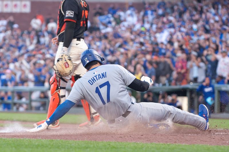 Jun 29, 2024; San Francisco, California, USA; Los Angeles Dodgers two-way player Shohei Ohtani (17) slides into home plate during the eleventh inning against the San Francisco Giants at Oracle Park. Mandatory Credit: Ed Szczepanski-USA TODAY Sports