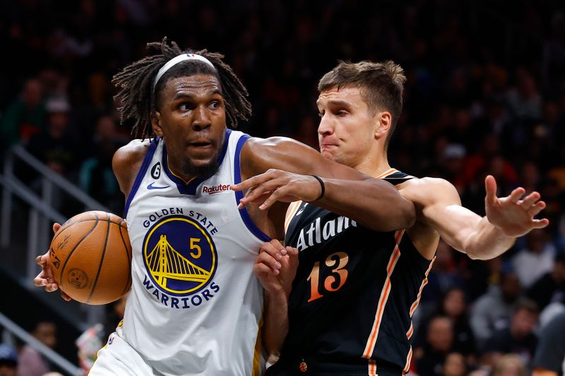 ATLANTA, GA - MARCH 17: Kevon Looney #5 of the Golden State Warriors drives against Bogdan Bogdanovic #13 of the Atlanta Hawks during the second half at State Farm Arena on March 17, 2023 in Atlanta, Georgia. NOTE TO USER: User expressly acknowledges and agrees that, by downloading and or using this photograph, User is consenting to the terms and conditions of the Getty Images License Agreement. (Photo by Todd Kirkland/Getty Images)