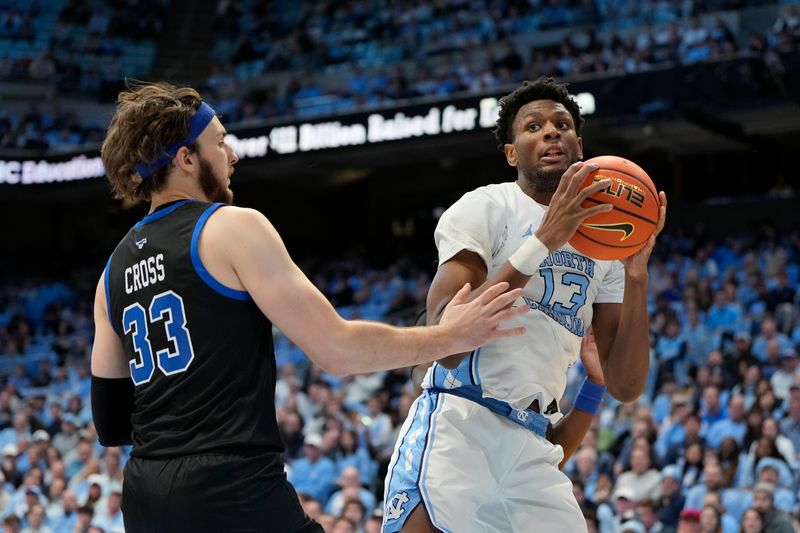 Jan 7, 2025; Chapel Hill, North Carolina, USA; North Carolina Tar Heels forward Jalen Washington (13) with the ball as Southern Methodist Mustangs forward Matt Cross (33) defends in the first half at Dean E. Smith Center. Mandatory Credit: Bob Donnan-Imagn Images