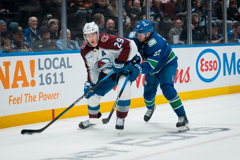 Nov 9, 2025; Vancouver, British Columbia, CAN;Vancouver Canucks forward Max Sasson (63) battles with Colorado Avalanche forward Nathan MacKinnon (29)  in the first period at Rogers Arena. Mandatory Credit: Bob Frid-Imagn Images