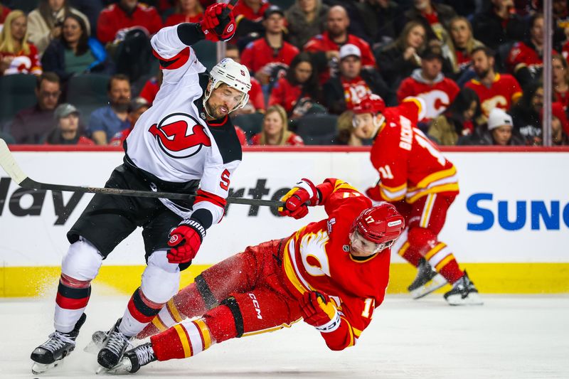 Jan 19, 2026; Calgary, Alberta, CAN; Calgary Flames center Yegor Sharangovich (17) and New Jersey Devils defenseman Brenden Dillon (5) collide during the second period at Scotiabank Saddledome. Mandatory Credit: Sergei Belski-Imagn Images