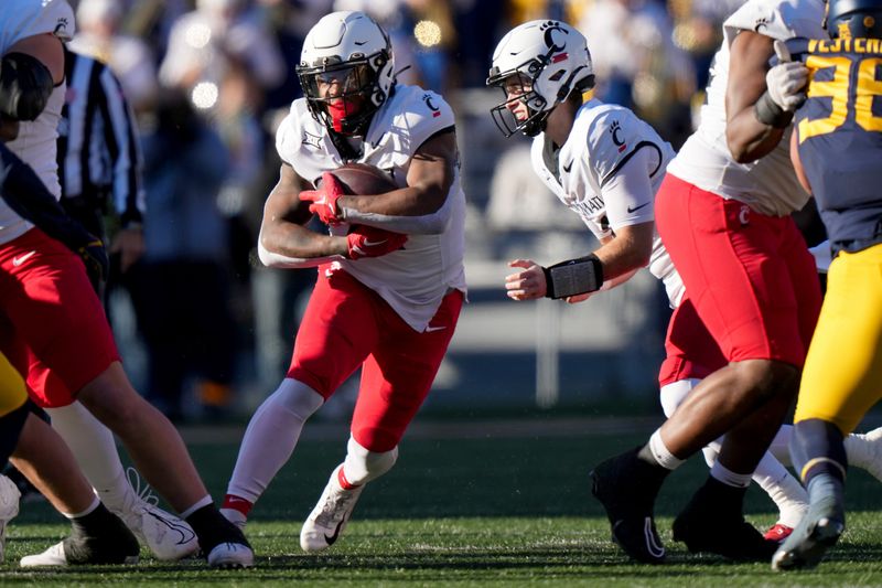 Nov 18, 2023; Morgantown, West Virginia, USA; Cincinnati Bearcats running back Corey Kiner (21) carries the ball against the West Virginia Mountaineers in the first quarter at Milan Puskar Stadium.  Mandatory Credit: Kareem Elgazzar-USA TODAY Sports