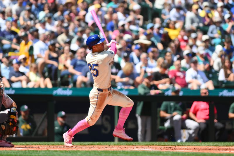 May 12, 2024; Seattle, Washington, USA; Seattle Mariners shortstop Dylan Moore (25) hits an RBI sacrifice fly against the Oakland Athletics during the second inning at T-Mobile Park. Mandatory Credit: Steven Bisig-USA TODAY Sports