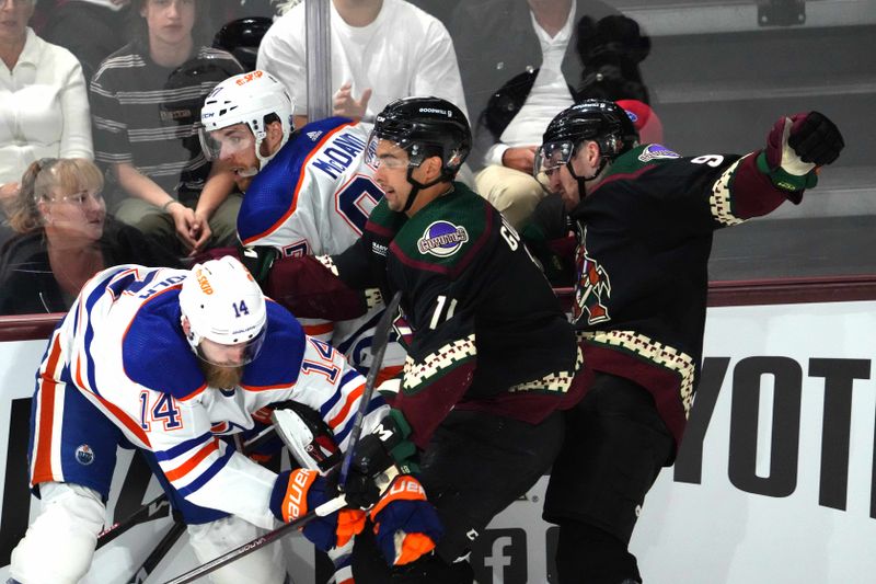 Feb 19, 2024; Tempe, Arizona, USA; Edmonton Oilers defenseman Mattias Ekholm (14) and Edmonton Oilers center Connor McDavid (97) and Arizona Coyotes right wing Dylan Guenther (11) and Arizona Coyotes defenseman J.J. Moser (90) battle along the boards during the third period at Mullett Arena. Mandatory Credit: Joe Camporeale-USA TODAY Sports