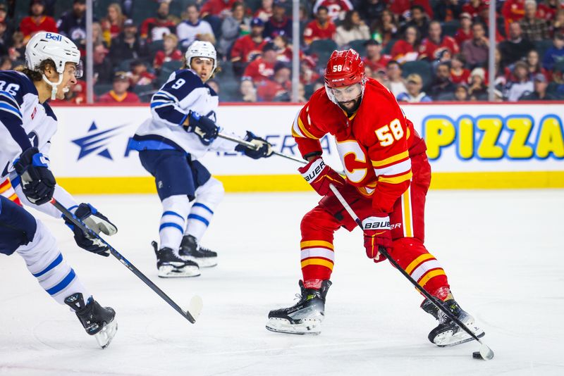 Feb 19, 2024; Calgary, Alberta, CAN; Calgary Flames defenseman Oliver Kylington (58) controls the puck against the Winnipeg Jets during the second period at Scotiabank Saddledome. Mandatory Credit: Sergei Belski-USA TODAY Sports