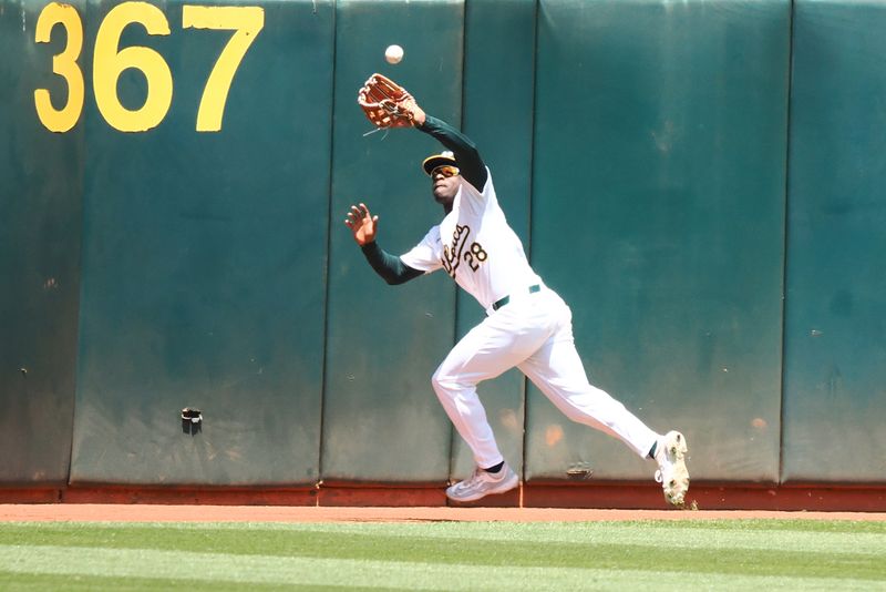 May 25, 2024; Oakland, California, USA; Oakland Athletics left fielder Daz Cameron (28) catches the ball against the Houston Astros during the fourth inning at Oakland-Alameda County Coliseum. Mandatory Credit: Kelley L Cox-USA TODAY Sports