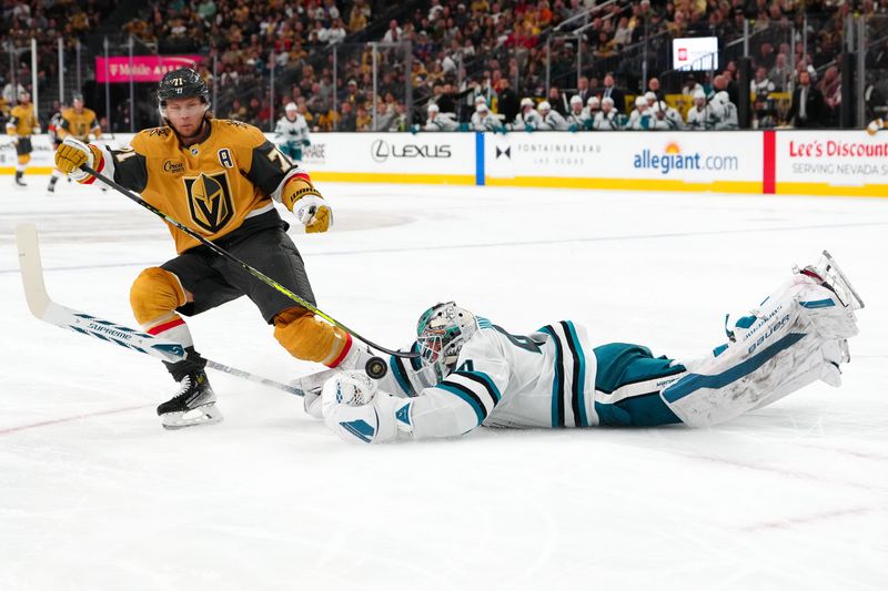 Oct 26, 2024; Las Vegas, Nevada, USA; Vegas Golden Knights center William Karlsson (71) tips the puck over the stick of San Jose Sharks goaltender Vitek Vanecek (41) during the second period at T-Mobile Arena. Mandatory Credit: Stephen R. Sylvanie-Imagn Images