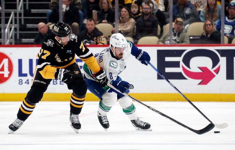 Jan 11, 2024; Pittsburgh, Pennsylvania, USA; Vancouver Canucks right wing Conor Garland (8) moves the puck up ice was Pittsburgh Penguins center Jeff Carter (77)  defends during the second period at PPG Paints Arena. Mandatory Credit: Charles LeClaire-USA TODAY Sports