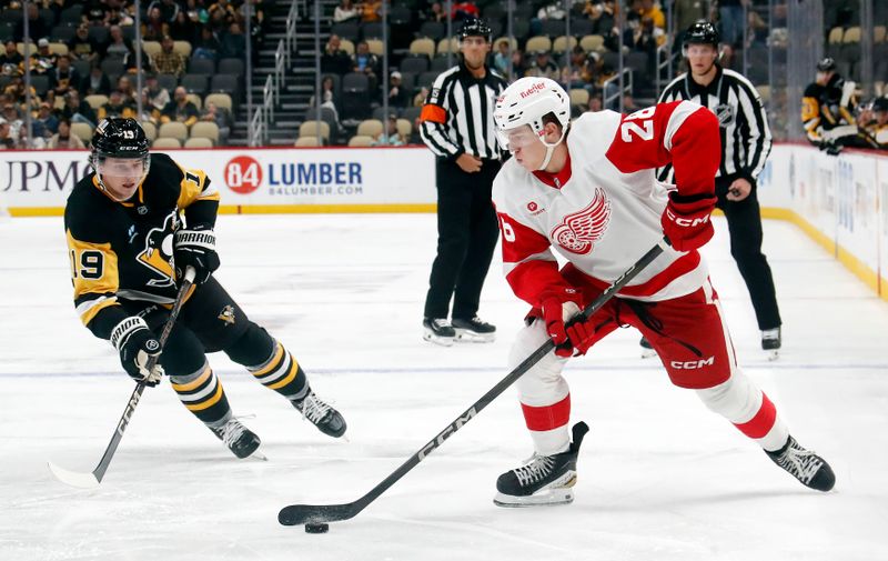 Oct 1, 2024; Pittsburgh, Pennsylvania, USA;  Detroit Red Wings right wing Michael Brandsegg-Nygård (28) skates with the puck as Pittsburgh Penguins center Cody Glass (19) chases during the second period at PPG Paints Arena. Mandatory Credit: Charles LeClaire-Imagn Images