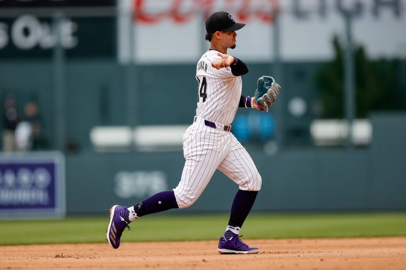 Apr 10, 2024; Denver, Colorado, USA; Colorado Rockies shortstop Ezequiel Tovar (14) makes a throw to first for an out in the fifth inning against the Arizona Diamondbacks at Coors Field. Mandatory Credit: Isaiah J. Downing-USA TODAY Sports