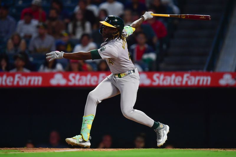 Jun 25, 2024; Anaheim, California, USA; Oakland Athletics outfielder Lawrence Butler (4) hits a sacrifice RBI against the Los Angeles Angels during the eighth inning at Angel Stadium. Mandatory Credit: Gary A. Vasquez-USA TODAY Sports