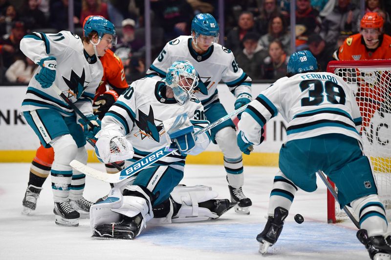 Dec 29, 2025; Anaheim, California, USA; San Jose Sharks center Macklin Celebrini (71) defenseman Shakir Mukhamadullin (85) and defenseman Mario Ferraro (38) help goaltender Yaroslav Askarov (30) defend the goal against the Anaheim Ducks during the second period at Honda Center. Mandatory Credit: Gary A. Vasquez-Imagn Images
