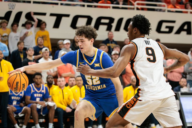 Feb 24, 2026; Stillwater, Oklahoma, USA; West Virginia Mountaineers forward Treysen Eaglestaff (52) drives to the basket around Oklahoma State Cowboys guard Anthony Roy (9) during the second half at Gallagher-Iba Arena. Mandatory Credit: William Purnell-Imagn Images