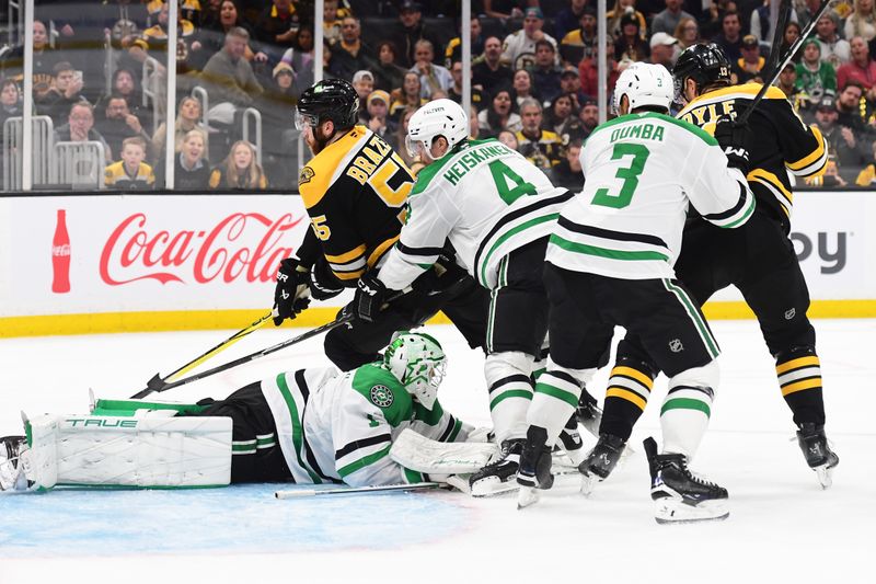 Oct 24, 2024; Boston, Massachusetts, USA;  Boston Bruins right wing Justin Brazeau (55) tries to tuck the puck past Dallas Stars goaltender Casey DeSmith (1) while defenseman Miro Heiskanen (4) defends during the third period at TD Garden. Mandatory Credit: Bob DeChiara-Imagn Images