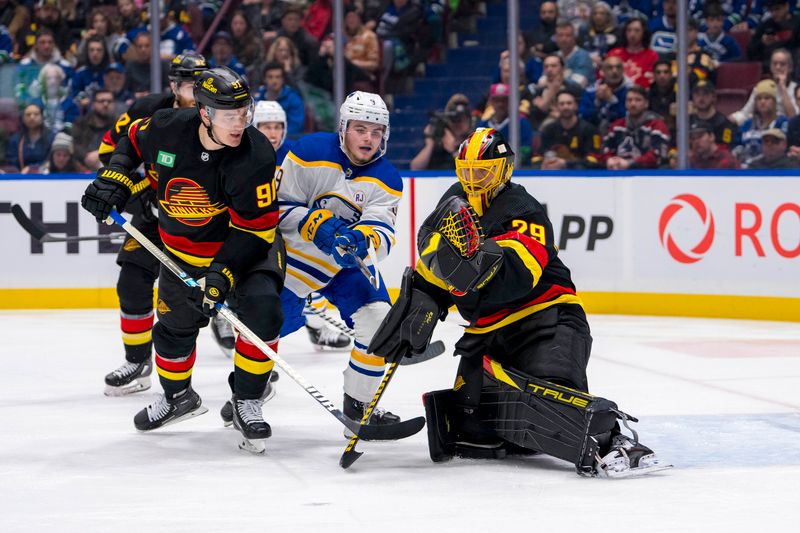 Mar 19, 2024; Vancouver, British Columbia, CAN; Vancouver Canucks defenseman Nikita Zadorov (91) and Buffalo Sabres forward Zach Benson (9) watch as goalie Casey DeSmith (29) makes a save in the second period at Rogers Arena. Mandatory Credit: Bob Frid-USA TODAY Sports