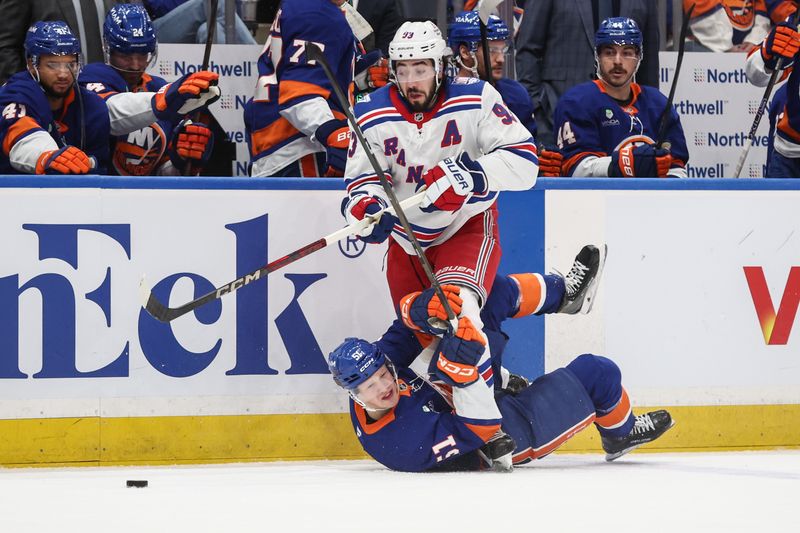 Dec 27, 2025; Elmont, New York, USA;  New York Rangers center Mika Zibanejad (93) and New York Islanders left wing Emil Heineman (51) battle for control of the puck at UBS Arena. Mandatory Credit: Wendell Cruz-Imagn Images