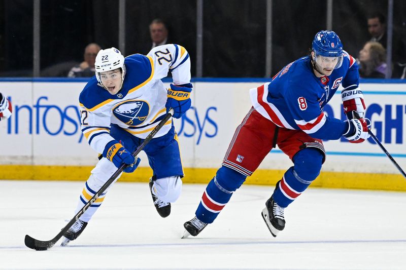 Nov 7, 2024; New York, New York, USA;  Buffalo Sabres right wing Jack Quinn (22) skates with the puck chased by New York Rangers defenseman Jacob Trouba (8) during the third period at Madison Square Garden. Mandatory Credit: Dennis Schneidler-Imagn Images