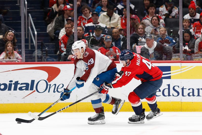 Feb 13, 2024; Washington, District of Columbia, USA; Colorado Avalanche center Nathan MacKinnon (29) skates with the puck as Washington Capitals left wing Beck Malenstyn (47) defends in the second period at Capital One Arena. Mandatory Credit: Geoff Burke-USA TODAY Sports