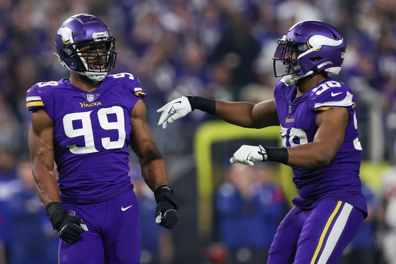 Minnesota Vikings linebackers Danielle Hunter (99) and D.J. Wonnum (98) react after a play during the second half of an NFL wild-card football game against the New York Giants, Sunday, Jan. 15, 2023 in Minneapolis. (AP Photo/Stacy Bengs)